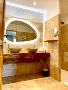 łazienka z 2 umywalkami i dużym lustrem w obiekcie Château le Bouïs w mieście Gruissan