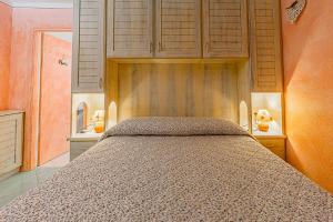 1 dormitorio con 1 cama y armarios de madera en Claude&Kate's dream house, en Porto San Paolo