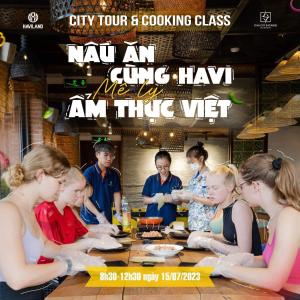 Eine Gruppe von Menschen, die an einem Tisch sitzen und Essen essen. in der Unterkunft Star City Riverside Hotel By Haviland in Đà Nẵng