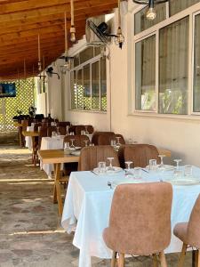 a dining room with tables and chairs and windows at BlackStone.Shkodra in Shkodër