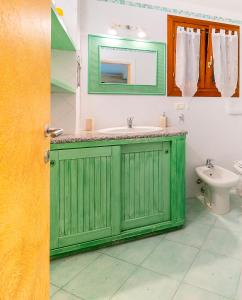Claude&Kate's dream house في بورتو سان باولو: حمام أخضر مع حوض ومرحاض
