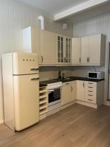 a kitchen with a white refrigerator and white cabinets at Kirkegata 7 in Sarpsborg