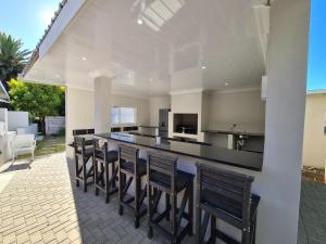 a kitchen with a bar with chairs and a counter at Lion Lodge in Bloemfontein