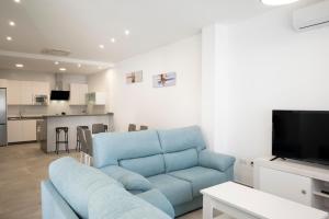 uma sala de estar com um sofá azul e uma cozinha em CASA DON ALEJANDRO y DOÑA FLORENCIA em Hornachuelos