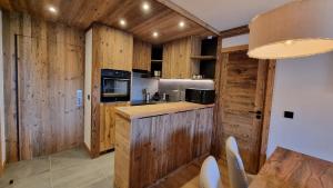 a kitchen with wooden cabinets and a counter top at Arcs 1950 Appartement Luxe type chalet 5 à 7 personnes Vue imprenable sur le Montblanc skis aux pieds in Arc 1950