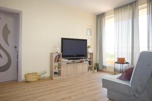 sala de estar con TV de pantalla plana y sofá en sea view hygge - Quiet residential apartment, en Kavarna