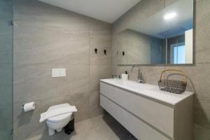 La salle de bains est pourvue d'un lavabo, de toilettes et d'un miroir. dans l'établissement Renovated 3 Bedrooms / 2 bath on Frishman st., à Tel Aviv