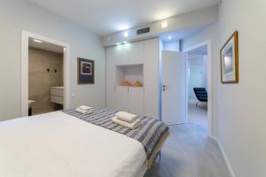 - une chambre avec un lit blanc et des serviettes dans l'établissement Renovated 3 Bedrooms / 2 bath on Frishman st., à Tel Aviv
