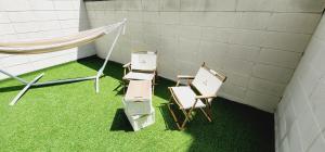 金海にあるDaon Hotel Gimhae Injaeの椅子とハンモック付きの芝生の上の部屋