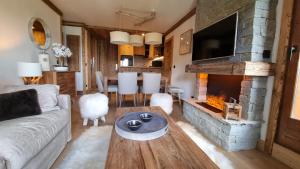 un soggiorno con divano e camino di Arcs 1950 Appartement Luxe type chalet 5 à 7 personnes Vue imprenable sur le Montblanc skis aux pieds ad Arc 1950