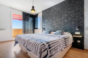 a bedroom with a large bed with a brick wall at Villa Sabela in Segur de Calafell +20 photos