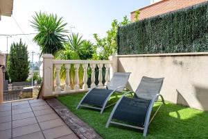 two chairs sitting on the grass near a fence at Villa Sabela in Segur de Calafell