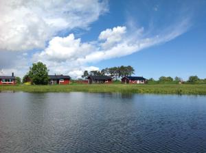 ein großer Wasserkörper mit Häusern im Hintergrund in der Unterkunft Svalsjöns Stugor Öland in Köpingsvik