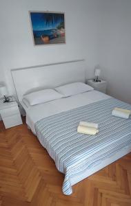 a bedroom with a large bed with two towels on it at Apartments and Rooms Batoš in Zavala