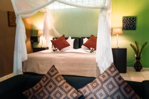 a bedroom with a bed with a canopy at Gabus Safari Lodge in Otavi