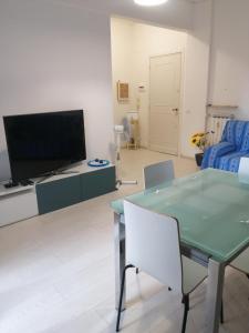 Una sala de estar con un televisor y una mesa y sillas. en Casa DaMa, en Savona