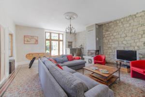 a living room with a couch and a tv at Le Grand Cèdre - Maison avec piscine privée in Ribes
