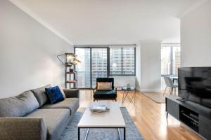 a living room with a couch and a tv at Midtown 2BR w Pool Gym Roof nr Subway NYC-385 in New York
