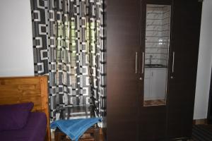 a living room with a cabinet and a curtain at Ben's Villa Kannur ! in Kannur