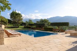 a swimming pool with a bench next to a patio at Malvazia Grand Estate, 4acre Immersed in Greenery, By ThinkVilla in Kermoútsi