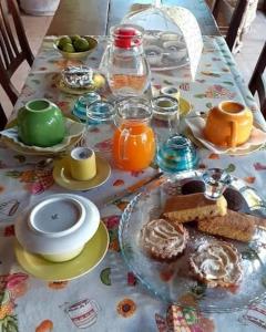 una mesa con alimentos para el desayuno y zumo de naranja en ella en Agriturismo Salaiolo 176 en Scansano