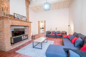 a living room with a blue couch and a fireplace at Le Montalbanais in Montauban