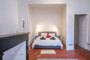 a bedroom with a bed with a red pillow on it at Le Montalbanais in Montauban