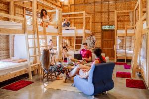 eine Gruppe von Personen, die in einem Zimmer mit Etagenbetten in Stühlen sitzen in der Unterkunft Society House Luxury Hostel in Pai