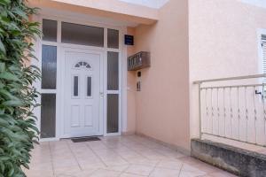 une porte blanche sur le côté du bâtiment dans l'établissement Charmante Wohnung fußläufig zum Meer in Funtana, à Funtana