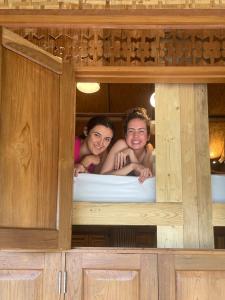 Zwei Mädchen liegen auf einem Bett in der Unterkunft Society House Luxury Hostel in Pai