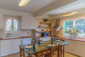 a kitchen with a table and chairs and a sink at Amor Villa in Laganas