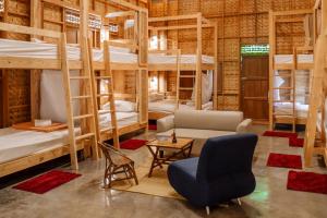 a room with bunk beds and a couch and a chair at Society House Luxury Hostel in Pai