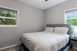a white bedroom with a bed and two windows at New Pet Friendly Walking Distance to Lake Front in Lake Geneva