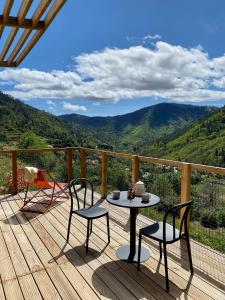 uma mesa e cadeiras num deque com vista para as montanhas em Casa Raposa Lodges - Terrace Mountain View em Manteigas