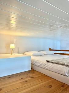 1 dormitorio con 2 camas y una lámpara en el suelo de madera en * Le Grand Hotel * Beau T1 Bis avec vue, en Font-Romeu-Odeillo-Via