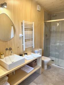 a bathroom with a sink and a toilet and a mirror at Casa Raposa Lodges - Terrace Mountain View in Manteigas +28 photos