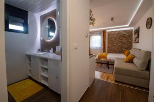uma cozinha e sala de estar com um lavatório e um sofá em Lux Apartman Sunce em Jagodina