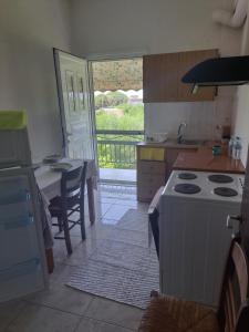 a kitchen with a stove and a table with a view at Stathis Rooms in Skafidia