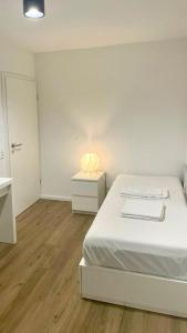1 dormitorio con cama y mesita de noche con lámpara en Pension RD Reutlingen, en Reutlingen