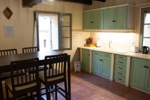 una cocina con armarios verdes, mesa y sillas en Columna Historya 1, en Bergerac