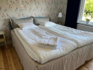 1 cama blanca grande con 2 toallas en Lovisas Stuga, en Vadstena