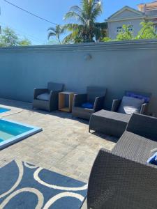 a patio with chairs and a swimming pool at Serenity northen 6-beds villa with private pool in Grand-Baie