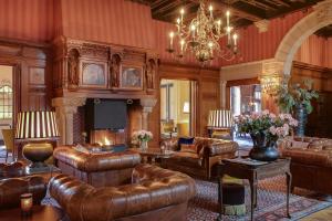 a large living room with leather furniture and a chandelier at Landgoed Duin & Kruidberg in Santpoort-Noord