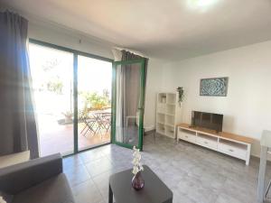 a living room with a couch and a television at RealRent Costa Teguise Beach in Costa Teguise