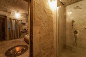 a bathroom with a shower and a dog laying in a bed at Göreme Escape Cave Suites in Goreme