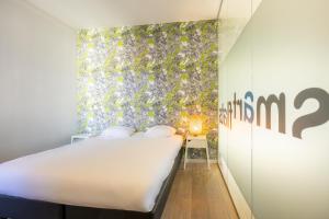 Un dormitorio con una cama y una pared con plantas. en Smartflats - Meir Antwerp, en Amberes