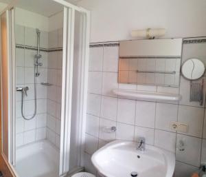 a bathroom with a shower and a sink and a toilet at Lenzerhof in Grän