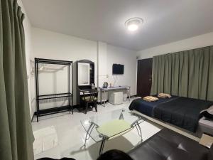 Schlafzimmer mit einem Bett, einem Schreibtisch und einem TV in der Unterkunft Morning Home บ้านหมอนอิง in Lop Buri