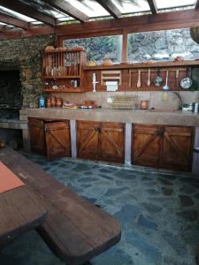 una cocina con armarios de madera y una pared de piedra. en Casa José, en Tajace de Abajo