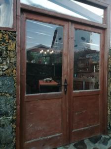 una antigua puerta de madera con una ventana en una pared de piedra en Casa José, en Tajace de Abajo